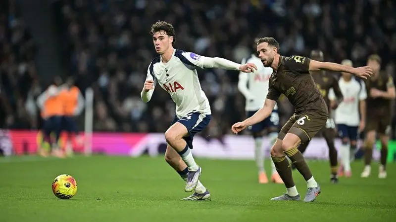 托特納姆熱刺隊的阿奇·格雷帶球擺脫了布倫特福德隊的喬丹·亨德森